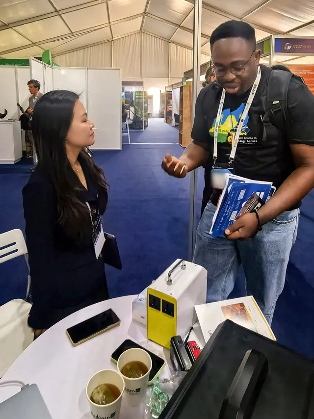 A member of the MOSON team talking with a visitor at the booth 32 table